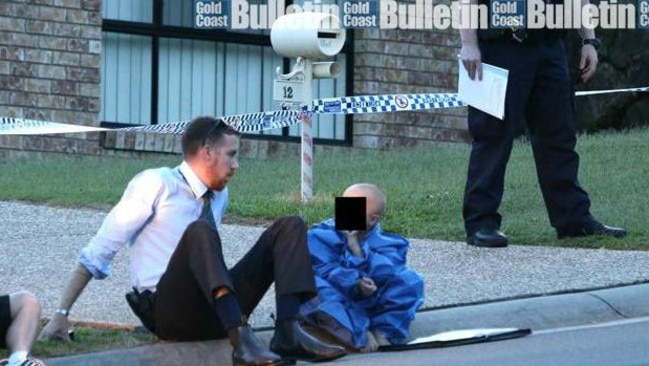 A young boy is comforted at the scene of an Upper Coomera double murder. Photo: Glenn Hampson