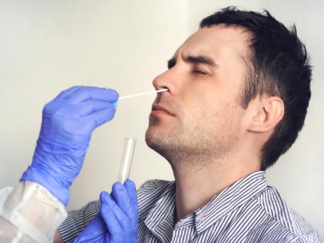 A doctor in a protective suit taking a nasal swab from a person to test for possible coronavirus infection. Nasal mucus testing for viral infections. Picture: iStock