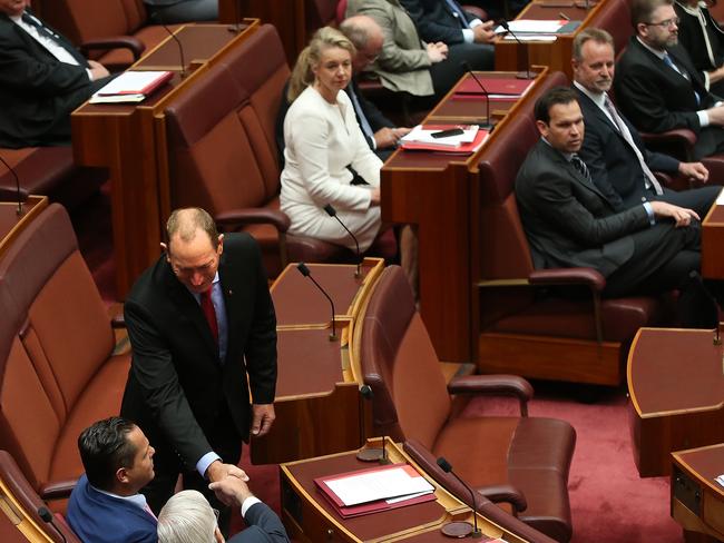 New Senator Fraser Anning after being sworn in shaking hands with Senator Senator Peter Georgiou and Senator Brian Burston in the Senate Chamber. Picture Kym Smith