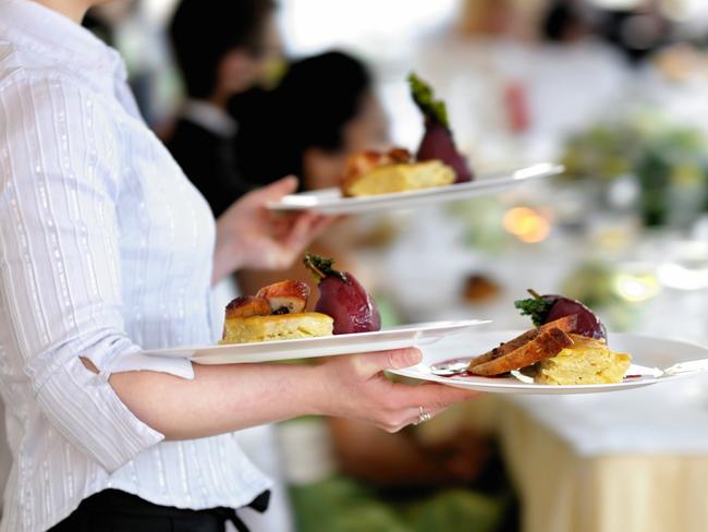 Waitress carrying three plates with meat dishGeneric photo of woman working in hospitality industry