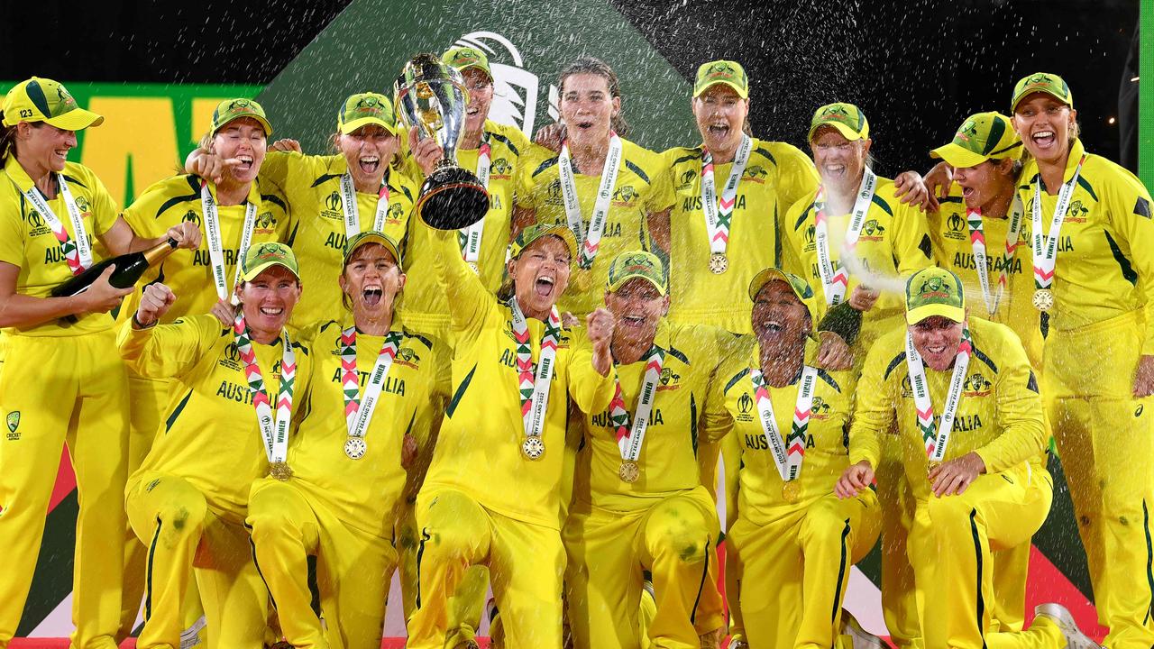 TOPSHOT - Australia's captain Meg Lanning (C) holds the trophy as team celebrate their win after the Women's Cricket World Cup final match between England and Australia at Hagley Park Oval in Christchurch on April 3, 2022. (Photo by Sanka VIDANAGAMA / AFP)