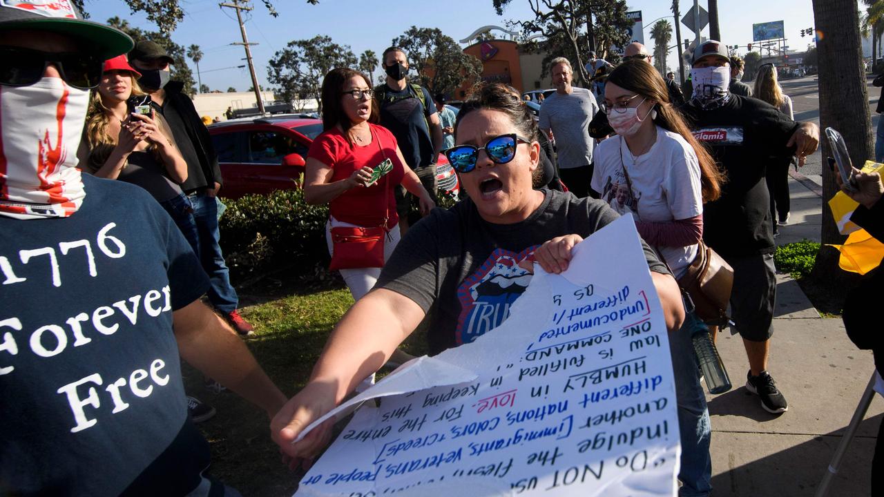 A pro-Trump demonstrator attending the march tears up a sign. Picture: Patrick T. Fallon/AFP