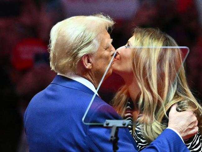 Former US President and Republican presidential candidate Donald Trump kisses former First Lady Melania Trump on stage during a campaign at Madison Square Garden in New York, October 27, 2024. (Photo by ANGELA WEISS / AFP)