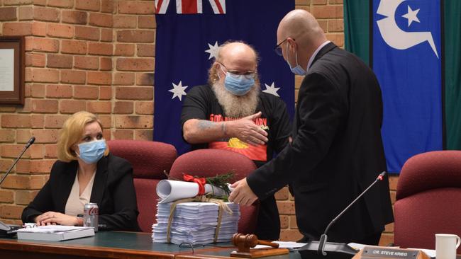 Mickey Ryan reaches out to Steve Krieg during a Lismore City Council meeting on Tuesday night.