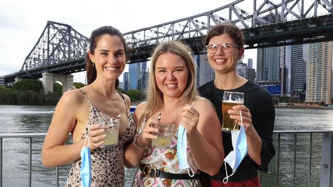 Giorgia York, Zoe Elves, and Megan Murdoch enjoyed a cold drink at Howard Smith Wharves after Queensland reached the 80 per cent first dose vaccination rate. Picture: Adam Head