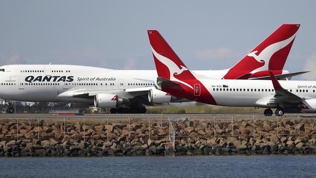 FILE - In this Aug. 20, 2015, file photo, two Qantas planes taxi on the runway at Sydney Airport in Sydney, Australia. The outbreak of the new virus threatens to erase $29 billion of this year's revenue for global airlines, mostly for Chinese carriers, as travel crashes worldwide, according to the International Air Transport Association. International airlines including British Airways, Germanyâ€™s Lufthansa, Australiaâ€™s Qantas and the three largest U.S. airlines have suspended flights to China, in some cases until late April or May. (AP Photo/Rick Rycroft, File)