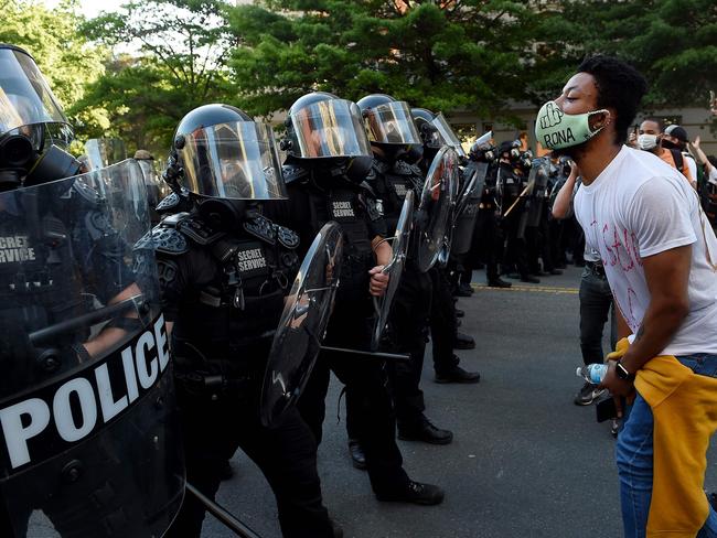 A protester faces off with secret service police in riot gear near the White House. Picture: AFP