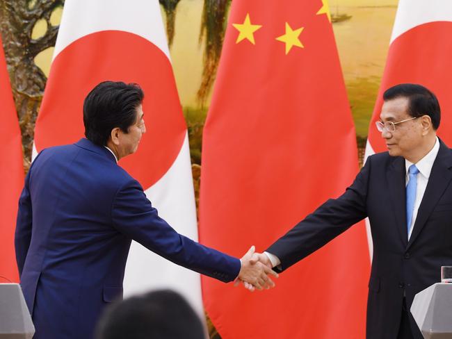 Japan's Prime Minister Shinzo Abe (L) shakes hands with Chinese Premier Li Keqiang after a joint briefing in the Great Hall of the People in Beijing on October 26, 2018. - Abe is on a three day state visit to China, the first visit to the Asian giant by a Japanese prime minister since relations between the two countries soured six years ago over a territorial row. (Photo by GREG BAKER / AFP)