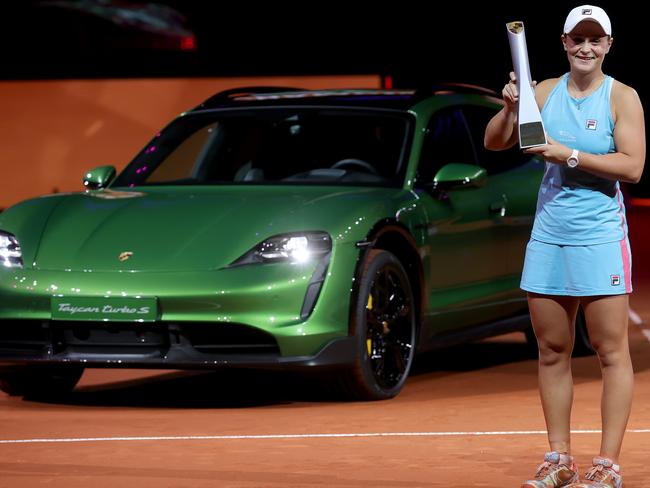 STUTTGART, GERMANY - APRIL 25: Ashleigh Barty of Australia  celebrates with the trophy in front of a Porsche Taycan Turbo S Cross Turismo after winning the final match against Aryna Sabalenka of Belarus during day 9 of the Porsche Tennis Grand Prix at Porsche Arena on April 25, 2021 in Stuttgart, Germany. Sporting arenas around Germany remain under strict restrictions due to the Coronavirus Pandemic as Government social distancing laws prohibit fans inside venues resulting in games being played behind closed doors. (Photo by Alex Grimm/Getty Images)