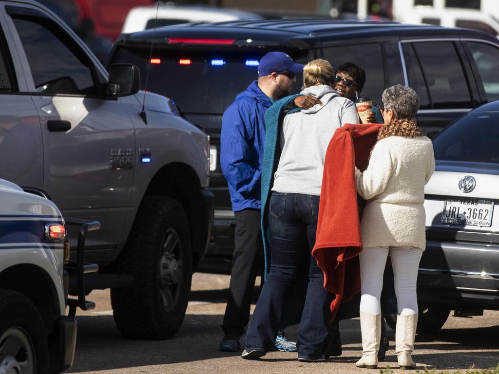 Residents embrace near police and fire cars that surround the scene of a shooting at a Texas church. Picture: AP