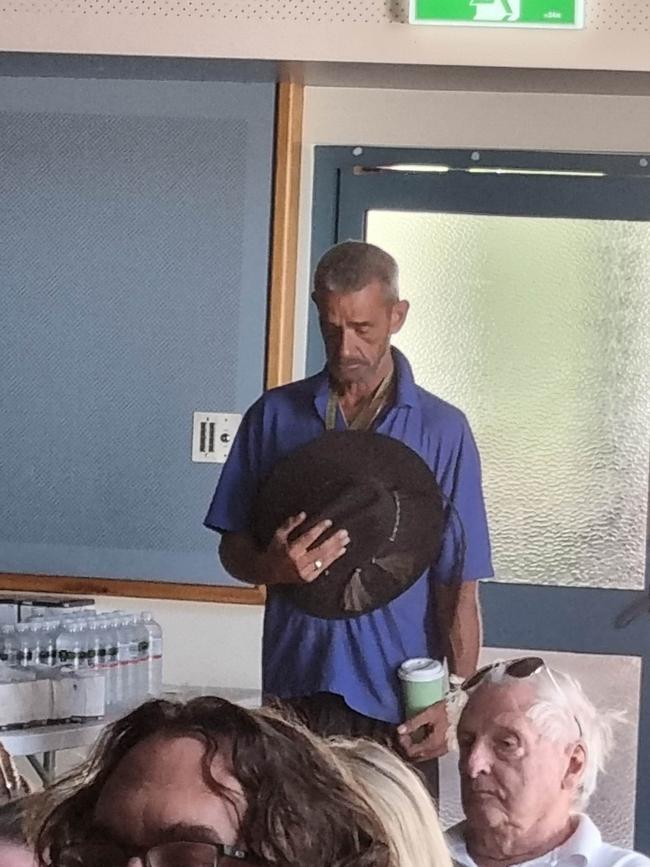 A Western Downs resident bows his head during the livestreaming of the funeral service.