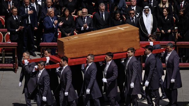 VUS President Donald Trump and other world leaders applaud as Francis’ coffin is carried out of St Peter’s Basilica on Saturday. Picture: AFP