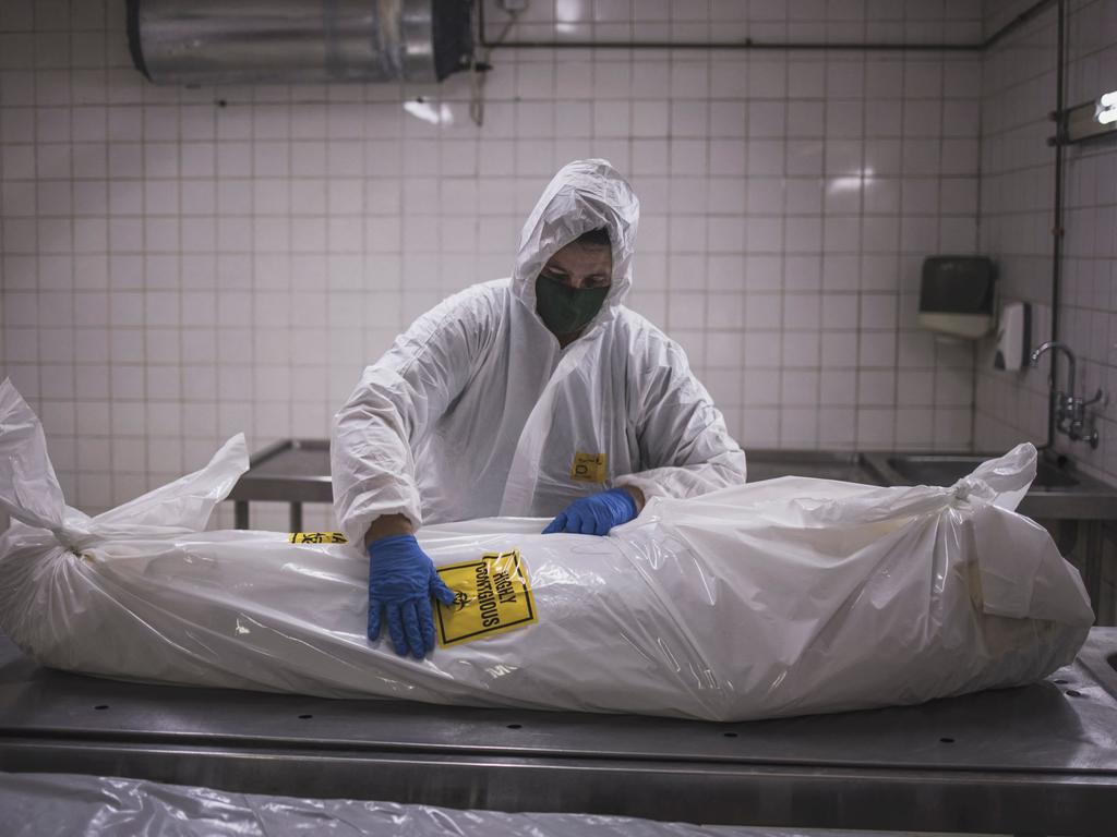 A Pretoria morgue attendant with the body of a Covid-19 patient in January 2021. Picture: Marco Longari/AFP
