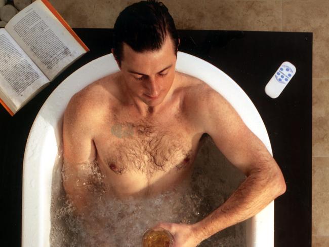 Man sitting in bath using spa Bubble Mat.