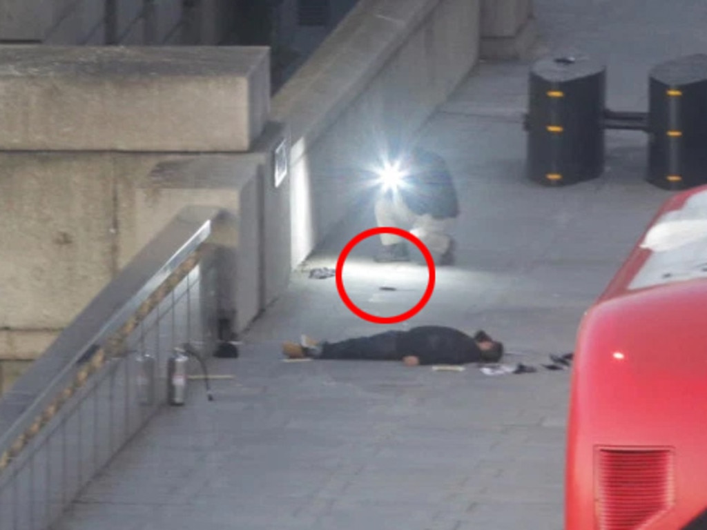 The terror suspect lies on London Bridge after being chased by witnesses armed with a narwhal tusk and a fire extinguisher before being shot by police. Picture: Cliff Hide / The Times