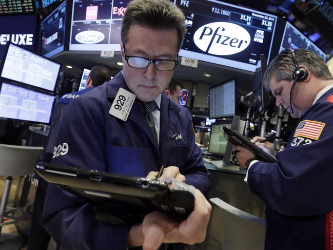 FILE - In this Nov. 23, 2015 file photo, traders James Matthews, left, and John Panin work at the post that handles Pfizer, on the floor of the New York Stock Exchange. Pfizer Inc. and Allergan Plc are scrambling to determine whether to proceed with their plan to merge. Both companies were mum Tuesday, April 5, 2016 on what they'll do, other than to swat swirling rumors that they’re leaning toward dropping the inversion. (AP Photo/Richard Drew)