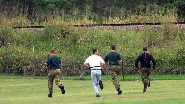 QLD police officers running to capture man Robert Paul Long.