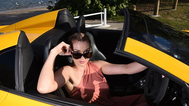 Brittany Capps in an yellow convertible McLaren Spider 650s. Photo: Steve Holland