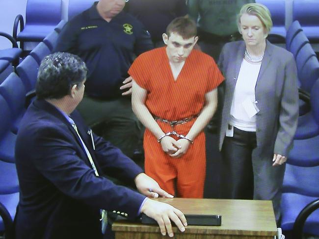 Hector Romero Assistant Public Defender (L) and Melisa McNeill, Public Defender (R) are seen on screen at the first appearance in court for high school shooting suspect Nikolas Cruz (C). Picture: AFP