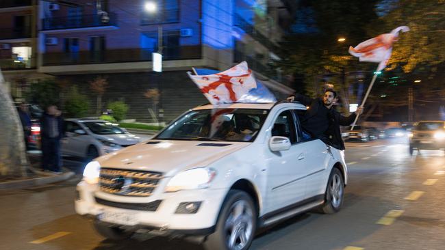 Georgian Dream Party supporters celebrate the exit poll results outside the Georgian Dream headquarters in Tbilisi on Saturday. Picture: Getty Images