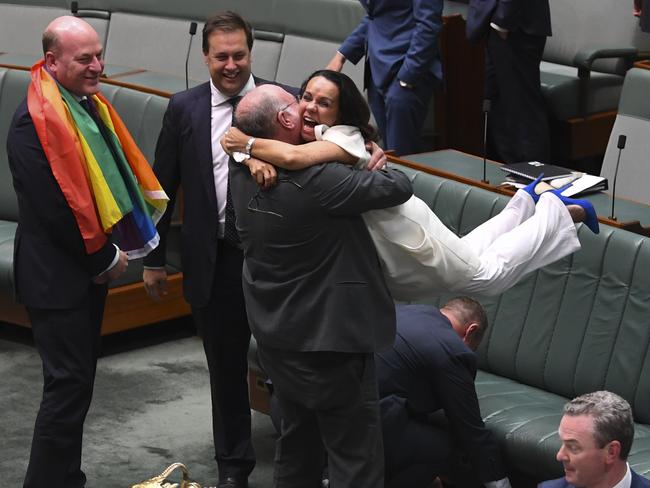 Liberal MP Warren Entsch lifts up Labor MP Linda Burney as they celebrate the passing of the Marriage Amendment Bill. Picture: AAP