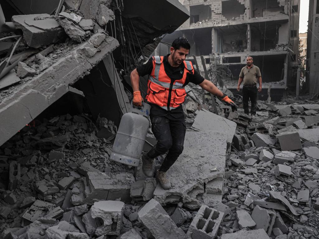 A rescuer salvages a gas canister from the rubble of a building after it was hit by an Israeli strike in Rafah in the southern Gaza Strip. Picture: AFP