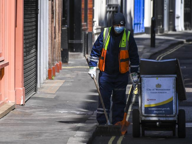 A road cleaner wears a mask in a deserted Carnaby Street in London. Picture: AP