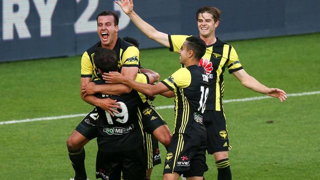 Wellington Phoenix’s Steven Taylor hugs teammate Tom Doyle while Sarpreet Singh and Alex Rufer also celebrate after the Roar’s own goal put the Phoenix ahead. Picture: Getty Images 