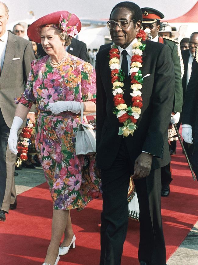 Queen Elizabeth II is escorted by Mugabe after her arrival at Harare Airport in 1991.