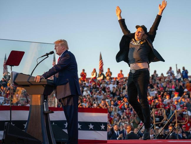 -- AFP PICTURES OF THE YEAR 2024 --  Tesla and SpaceX CEO Elon Musk (R) jumps on stage as he joins former US President and Republican Presidential candidate Donald Trump (L) during a campaign rally at the site of the former President's first assassination attempt, in Butler, Pennsylvania on October 5, 2024.Â  (Photo by Jim WATSON / AFP) / AFP PICTURES OF THE YEAR 2024