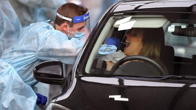 A member of the Australian Defence Force takes a swab sample at a drive-through COVID-19 coronavirus testing station in the Melbourne suburb of Fawkner. Picture: AFP