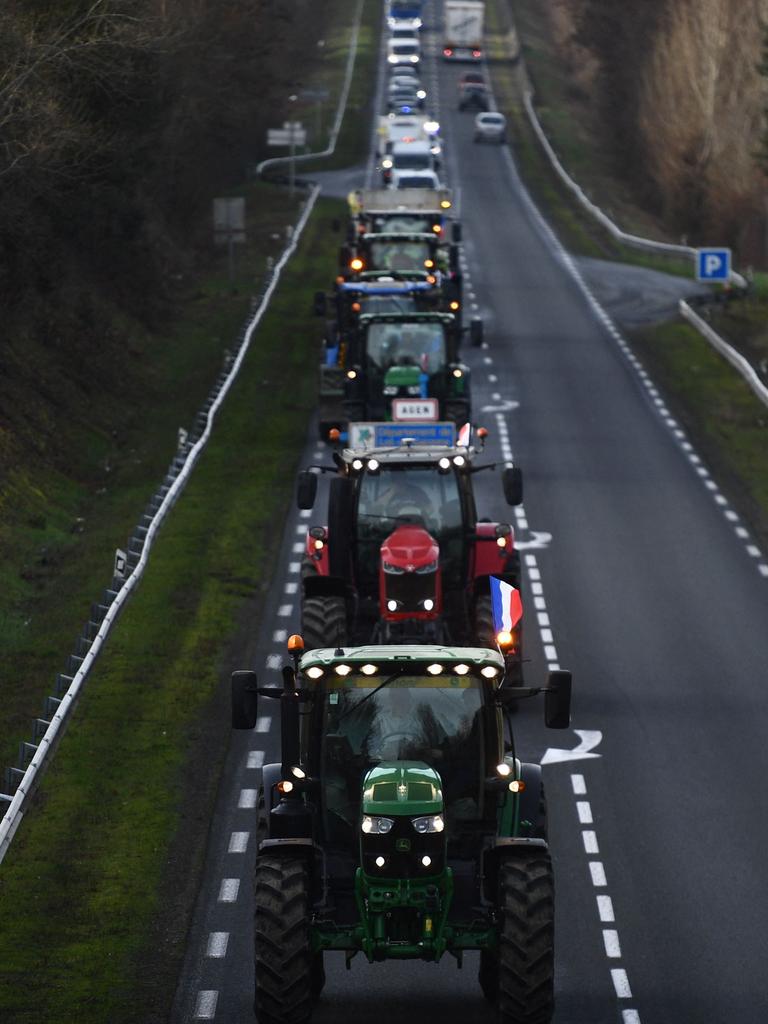 French farmers drive tractors in a convoy. (Photo by Christophe ARCHAMBAULT / AFP)