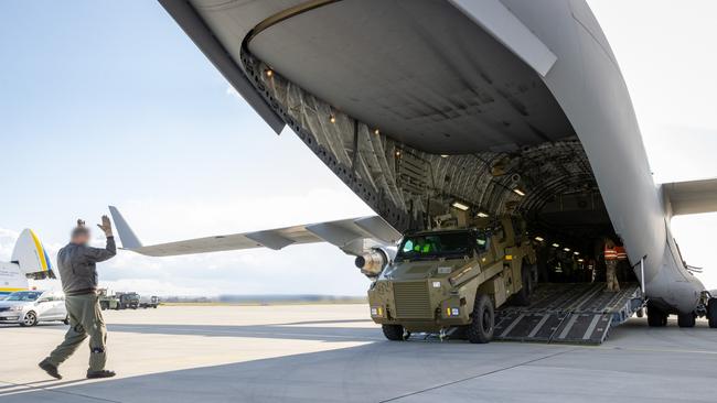 An Australian Army Bushmaster is unloaded from a Royal Australian Air Force C-17A Globemaster III at a European airport for forward movement to Ukraine. Labor has cleared out the defence department garages of junked, outdated equipment and shipped its antiques to Kyiv.