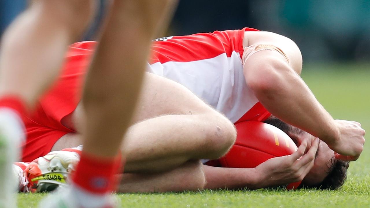 Paddy McCartin holds his head after a collision during the match between Hawthorn and the Sydney Swans.