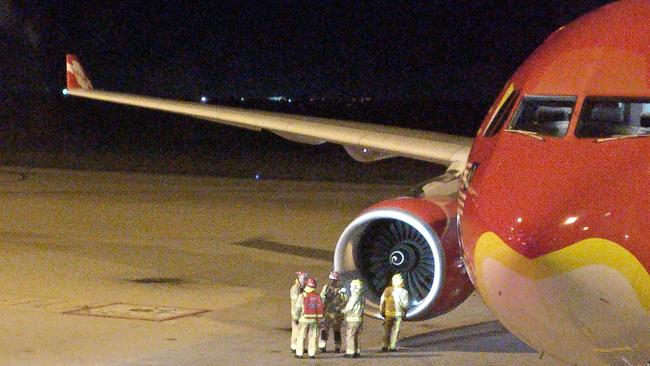 This picture taken by Calvin Boon on July 4, 2017 shows fire rescue personnel beside the starboard engine of an AirAsia Airbus A330, after the aircraft on flight D7207 made an emergency landing at the Brisbane International Airport. Photo: Calvin Boon