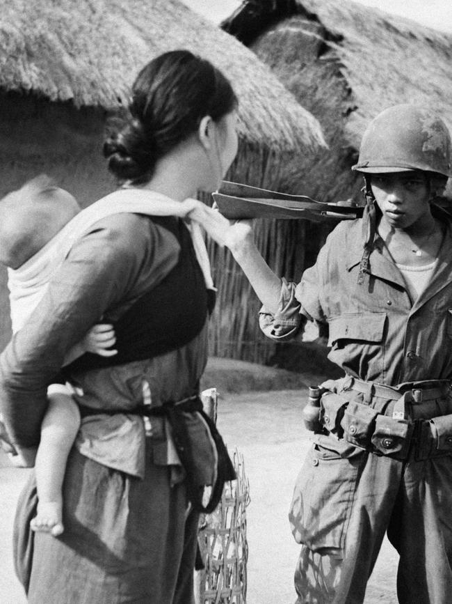 A Vietnamese auxiliary of the French army questions a Thai woman villager who had come to take refuge in the military post in 1951. Picture: AFP