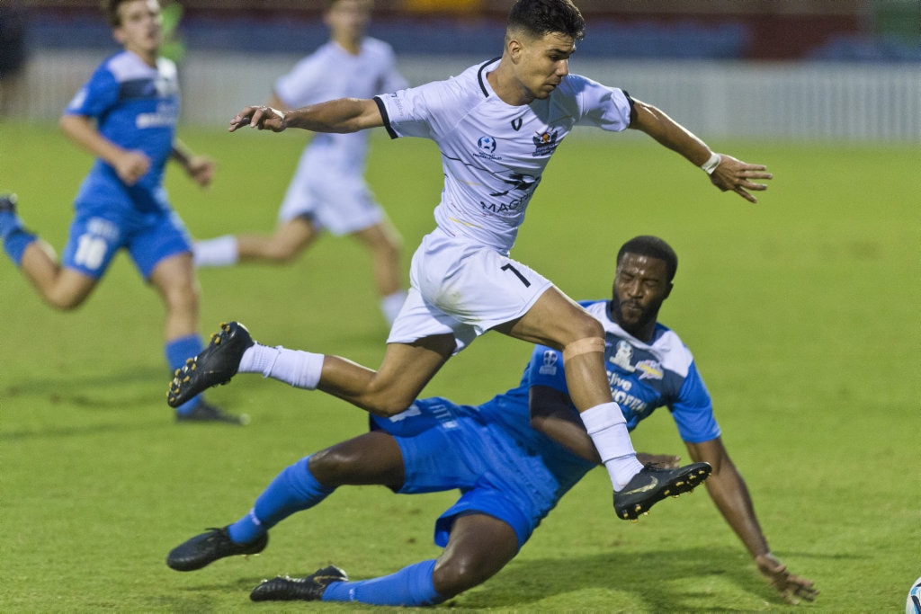 Kyren Walters of Magpies Crusaders leaps over a tackle from Joshua Choice of South West Queensland Thunder in NPL Queensland men round five football at Clive Berghofer Stadium, Saturday, March 2, 2019. Picture: Kevin Farmer