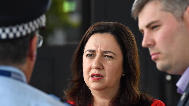 Queensland Premier Annastacia Palaszczuk (centre) talking to Queensland Police Commissioner Ian Stewart (left) and Queensland Police Minister Mark Ryan (right).(AAP Image/Darren England)