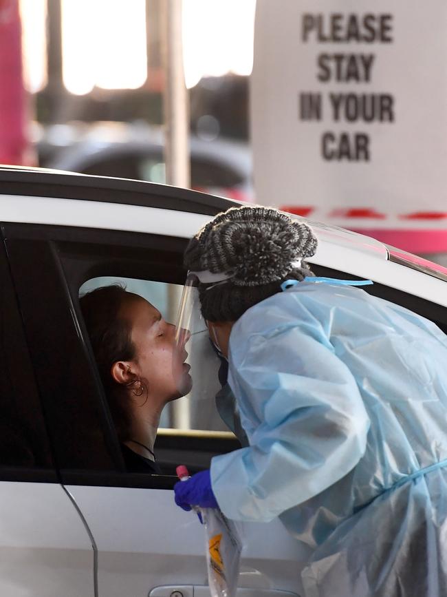 Medical workers staff a drive-through COVID-19 testing site located in a shopping centre carpark in Melbourne.