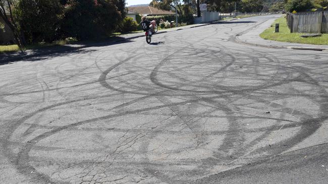 A motorcyclist does a wheelie along a burnout-covered Clarendon Vale street. Picture: The Mercury