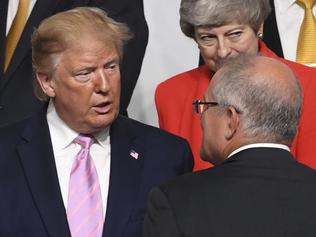 Australian Prime Minister Scott Morrison (right) speaks to President of the United States of America Donald Trump during the Leaders family photograph at the G20 summit in Osaka, Japan, Friday, June 28, 2019. The leaders of the world's largest economies arrived in Osaka on Thursday for the fourteenth meeting of Group of Twenty (G20). (AAP Image/Lukas Coch) NO ARCHIVING