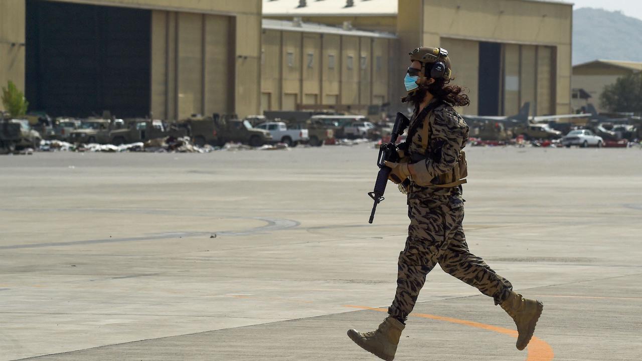 A member of the Taliban Badri 313 military unit runs to take up his position at the airport in Kabul.