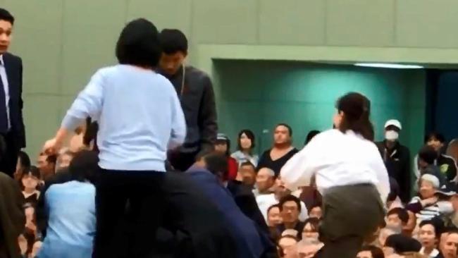 Women enter the ring to treat Maizuru mayor Ryozo Tatami, who collapsed while giving a speech on April 4. Picture: Reuters