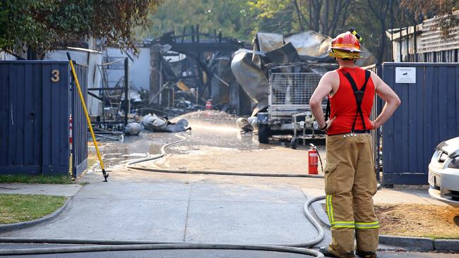 A firefighter inspects the damage caused by a series of gas bottle explosions.