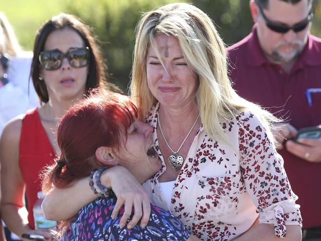 Parents wait for news after reports of the shooting. The incident happened on Ash Wednesday, a day many Catholics mark by wearing the sign of the cross on their foreheads. Picture: AP Photo/Joel Auerbach