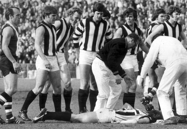 Teammates gather around John Greening as he lay unconscious after the big clash.