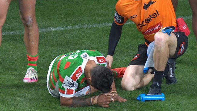 Latrell Mitchell is attended to by a trainer after suffering a hamstring injury