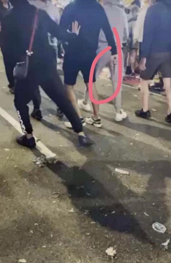 A man can be seen walking through the crowd while appearing to hold a knife. Picture: Facebook.