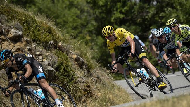 Great Britain's Christopher Froome (C), wearing the overall leader's yellow jersey, rides behind Australia's Richie Porte during the 161 km seventeenth stage of the 102nd edition of the Tour de France cycling race on July 22, 2015, between Digne-les-Bains and Pra Loup, southeastern France. AFP PHOTO / LIONEL BONAVENTURE