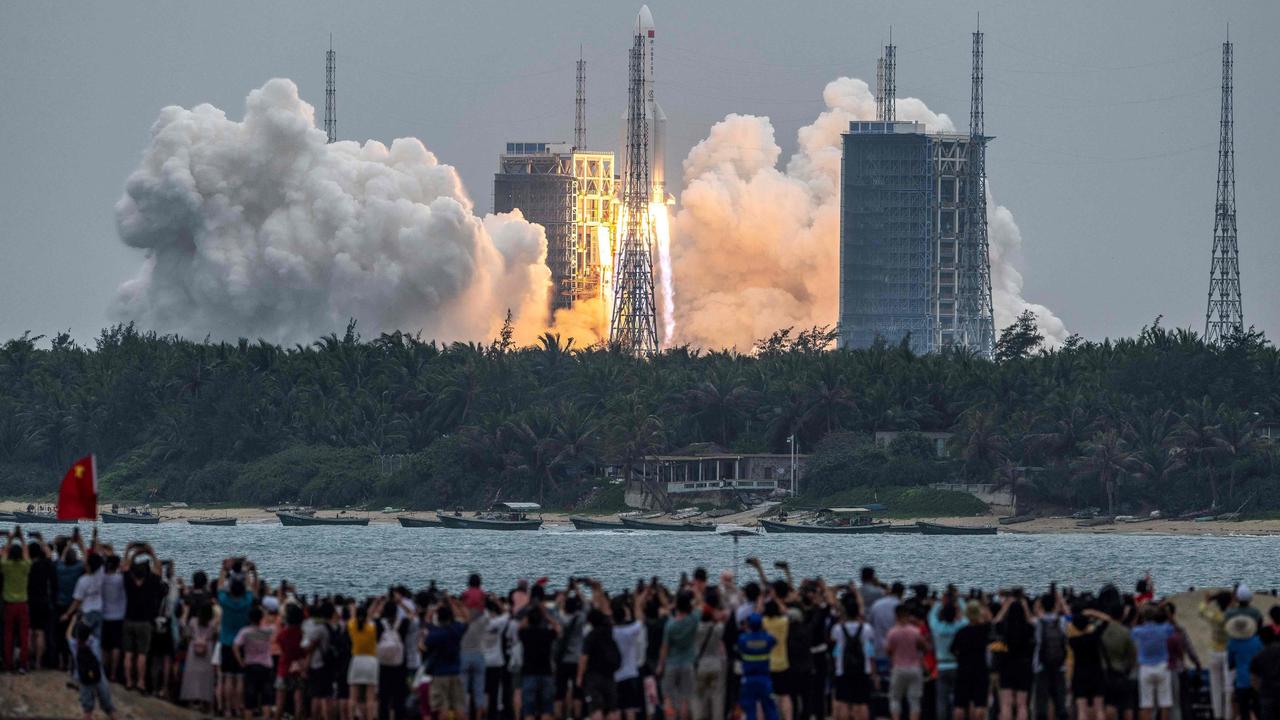 People watch a Long March 5B rocket launch in April. Picture: STR/AFP